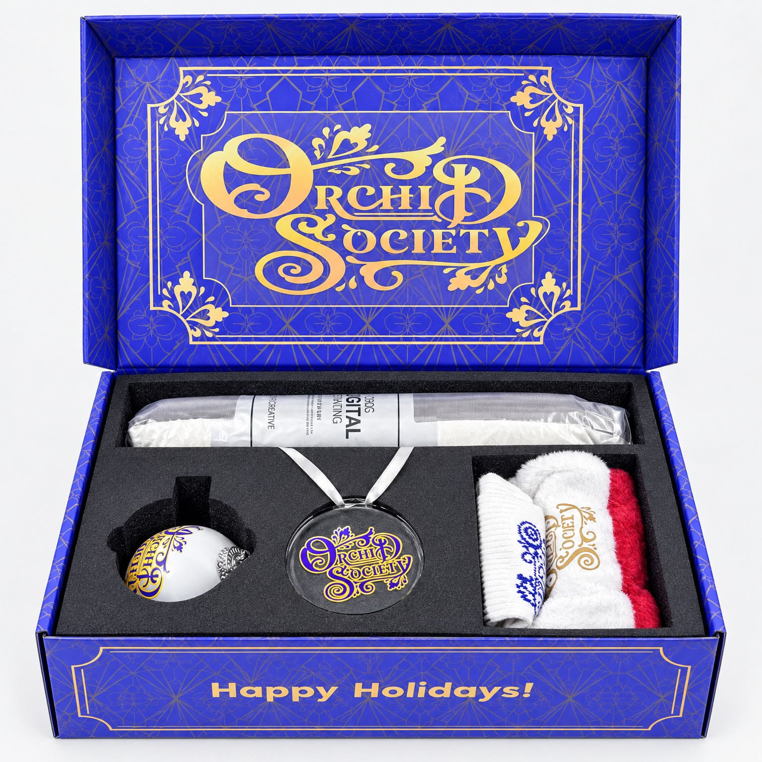 Open royal blue holiday gift box with a blanket, ornament, and socks